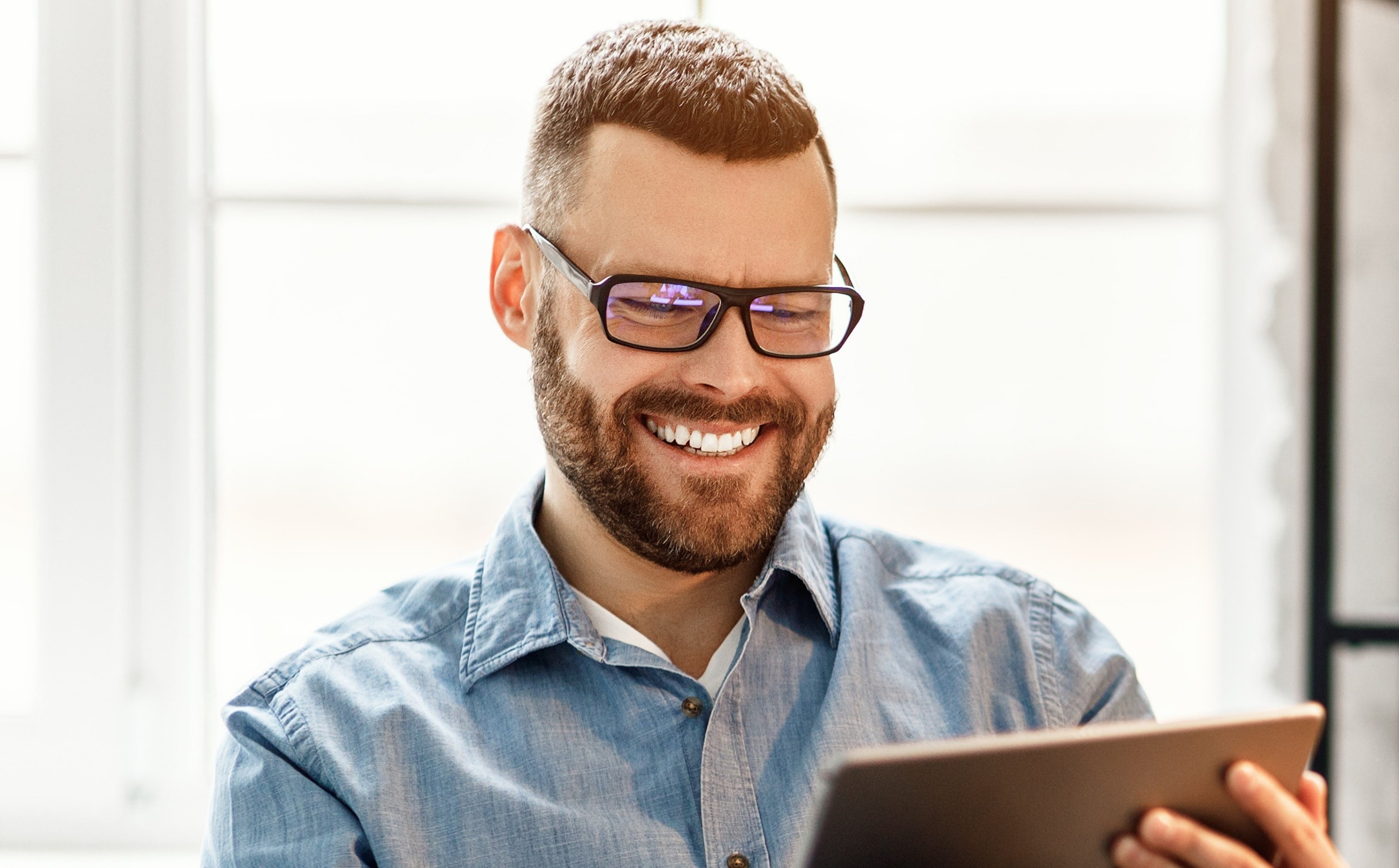 Male employee reading personalised message on tablet 